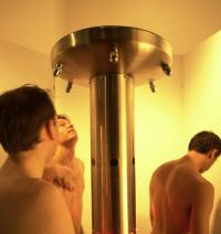 Patients showering at a Bradley six station column shower
          in the men's washdown room.